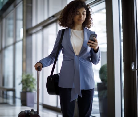 Business woman pulling suitcase through airport