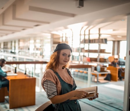 Young woman college student in library