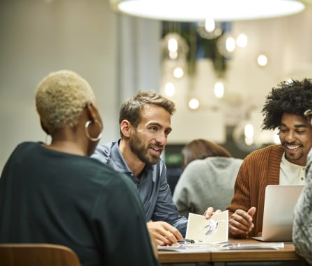 Group of young professionals talking together at a table