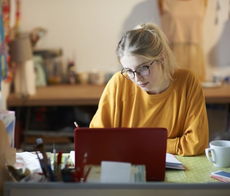 Young woman studying at a desk on a laptop