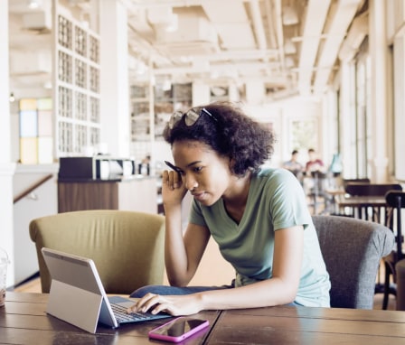 Young woman student on laptop in a cafe