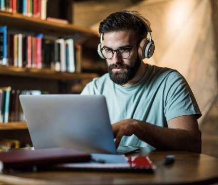 Man studying for a test on his laptop in a library