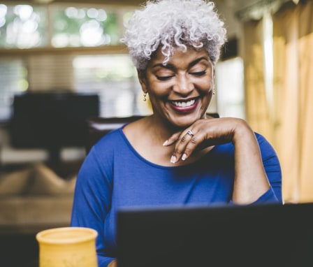 Woman at home smiling at laptop