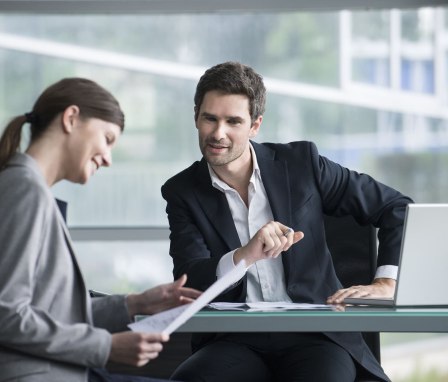 Two professionals meeting and reviewing papers