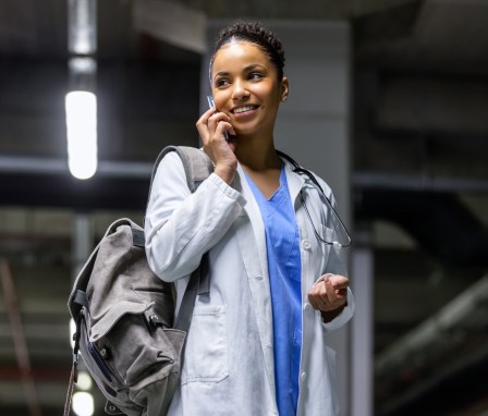 Medical professional talking on a cell phone in a parking garage