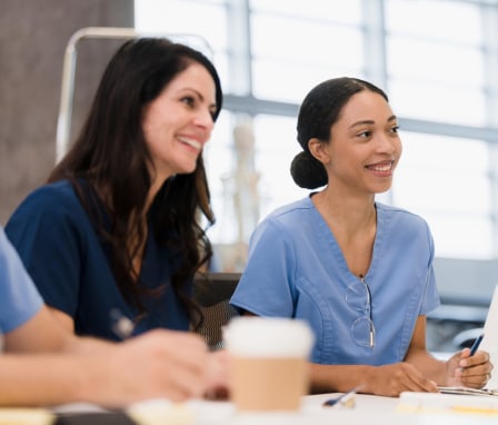 Female nursing students smile during lecture