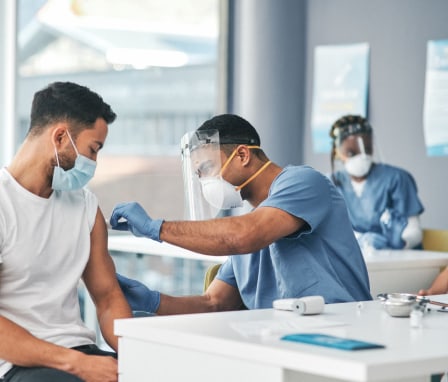 Shot of a patient receiving an injection at a Covid-19 vaccination center