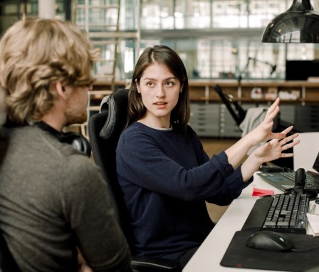 Entrepreneur explaining to colleague while sitting in office