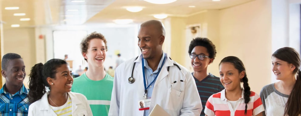 High school students standing with doctor
