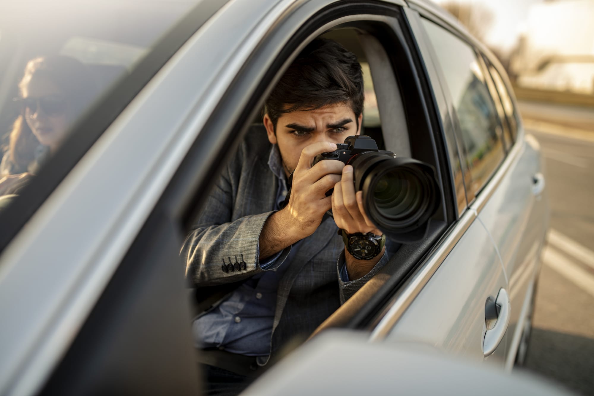 Man taking photographs out of a car window