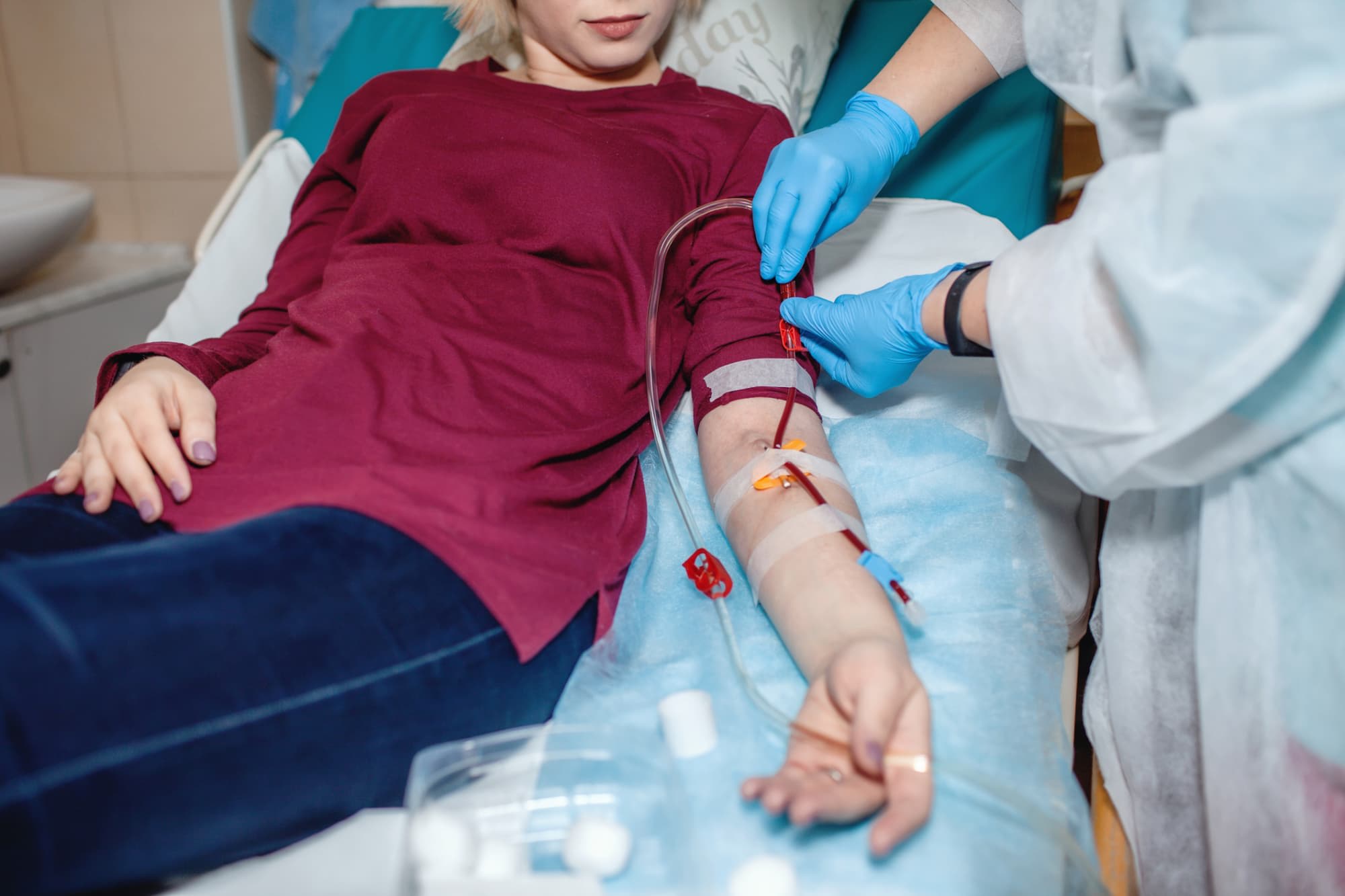 Patient hooked up to machines in a hospital getting help from a medical professional