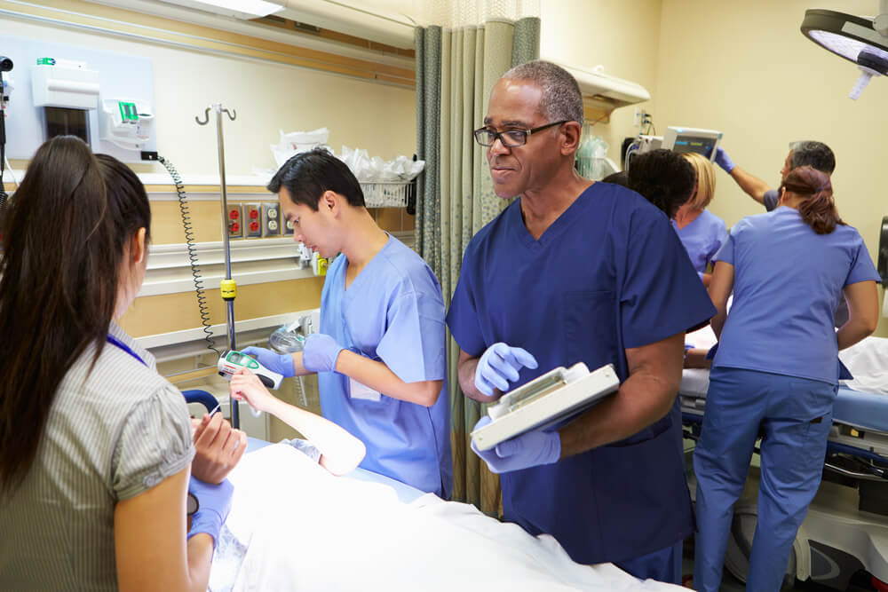 Team of nurses examining a patient in the emergency room. Image Credit: Monkey Business Images / Shutterstock