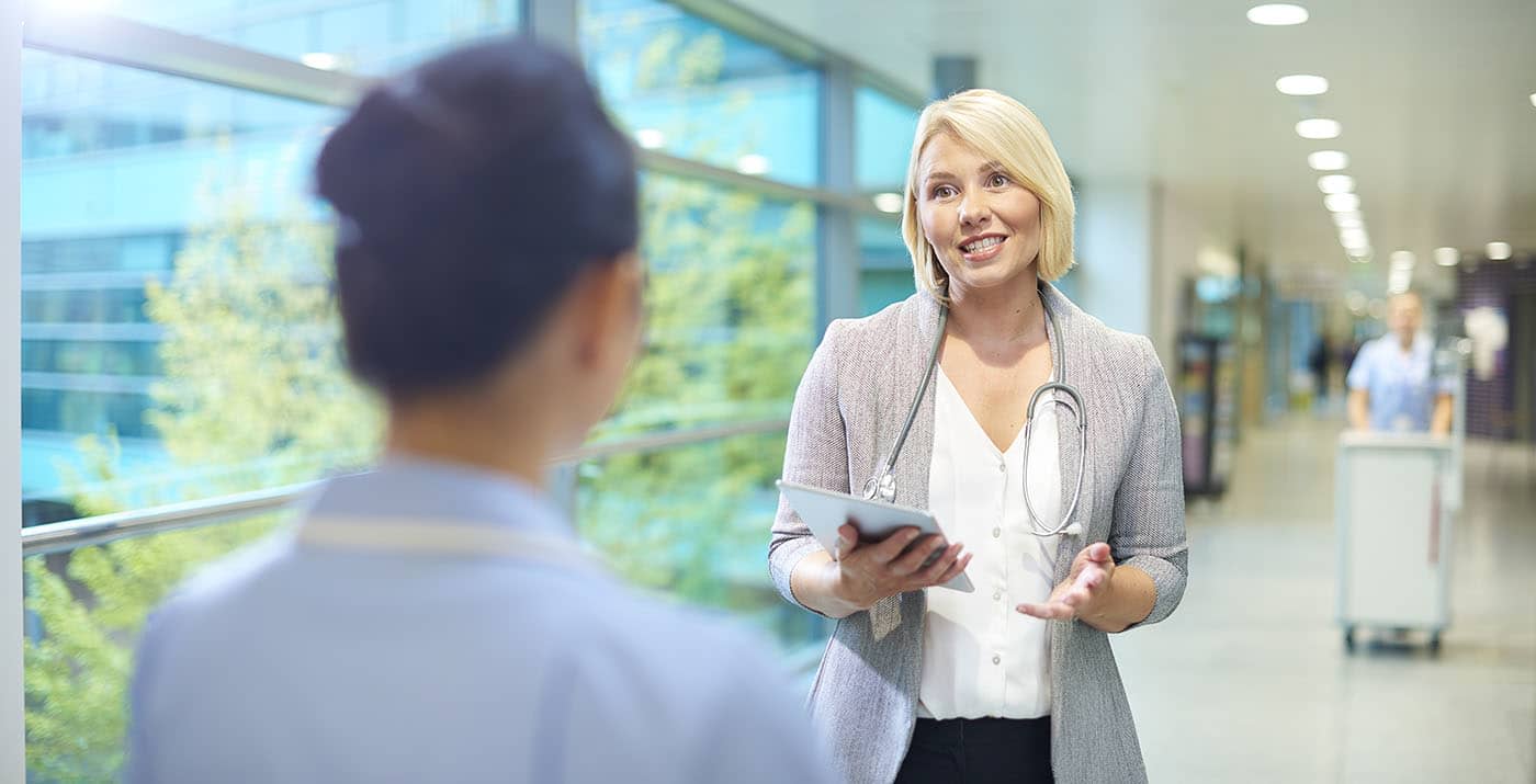 Two people talking in hospital hallway