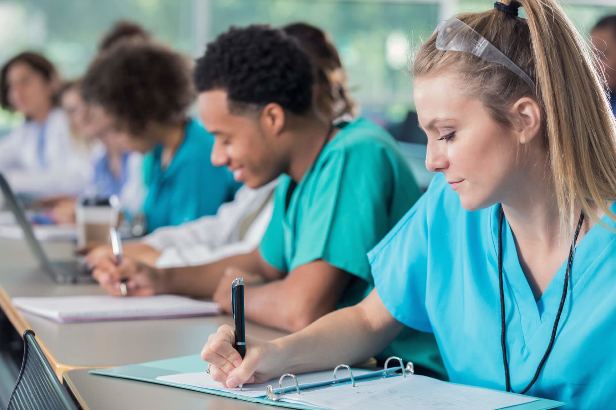 Diverse male and female young medical students confidently take notes