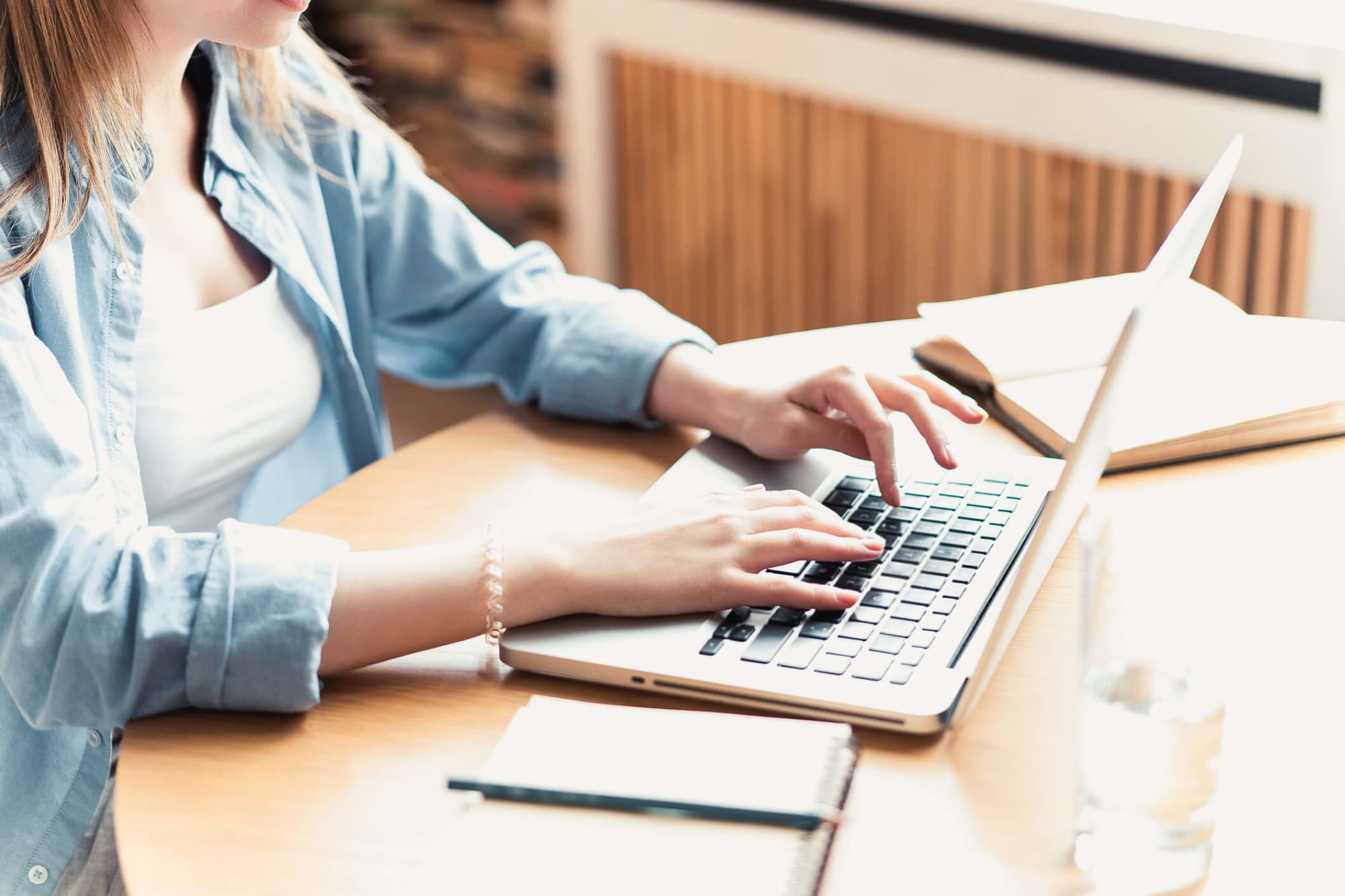 Woman at home typing her resume on her laptop.