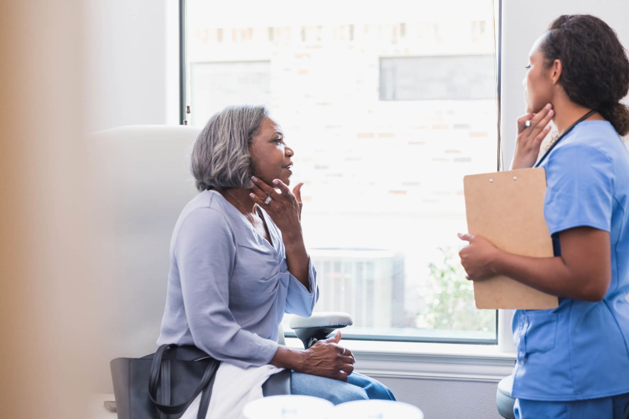 Senior patient speaking with dermatology nurse