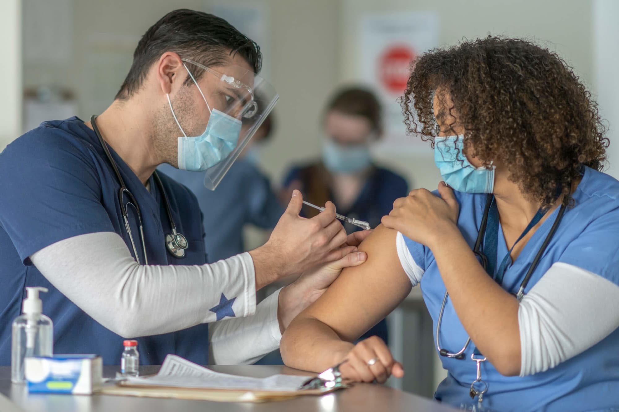 African-American female nurse receiving the COVID-19 vaccine