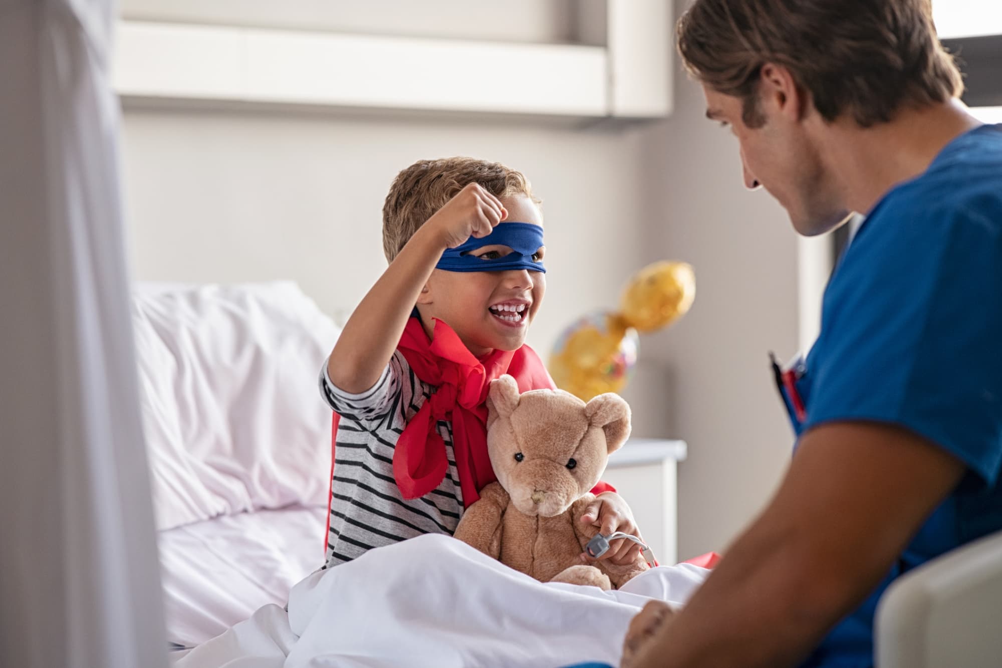 Pediatric nurse helping a kid dressed as a superhero