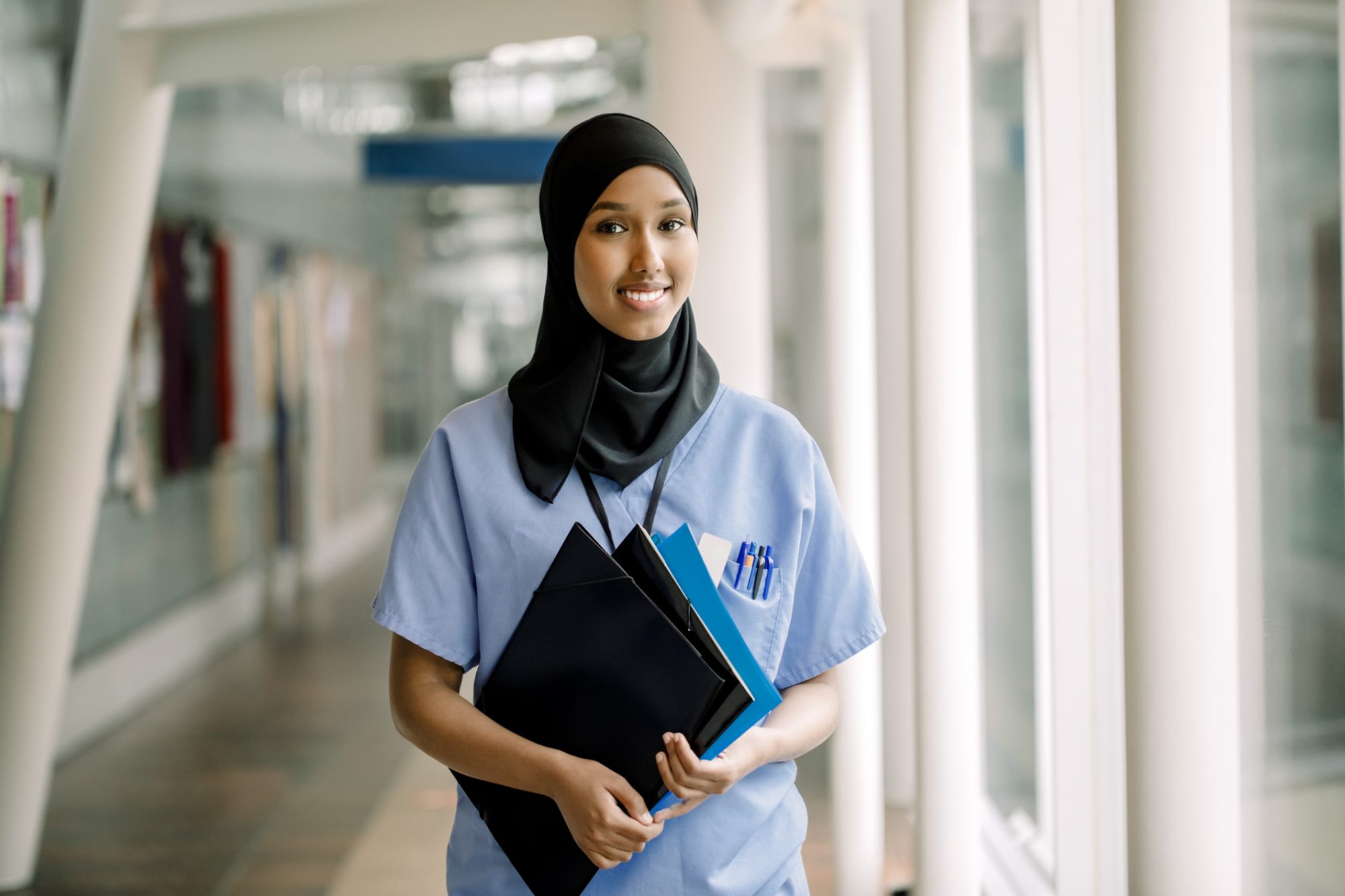Woman nurse smiling in hospital corridor