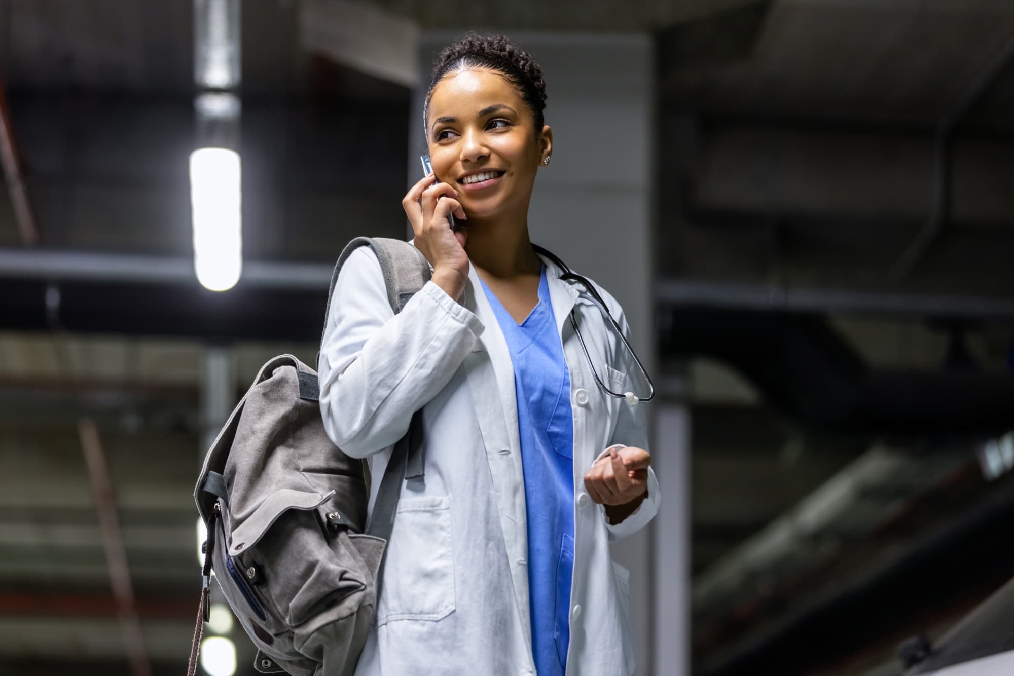 Medical professional talking on a cell phone in a parking garage