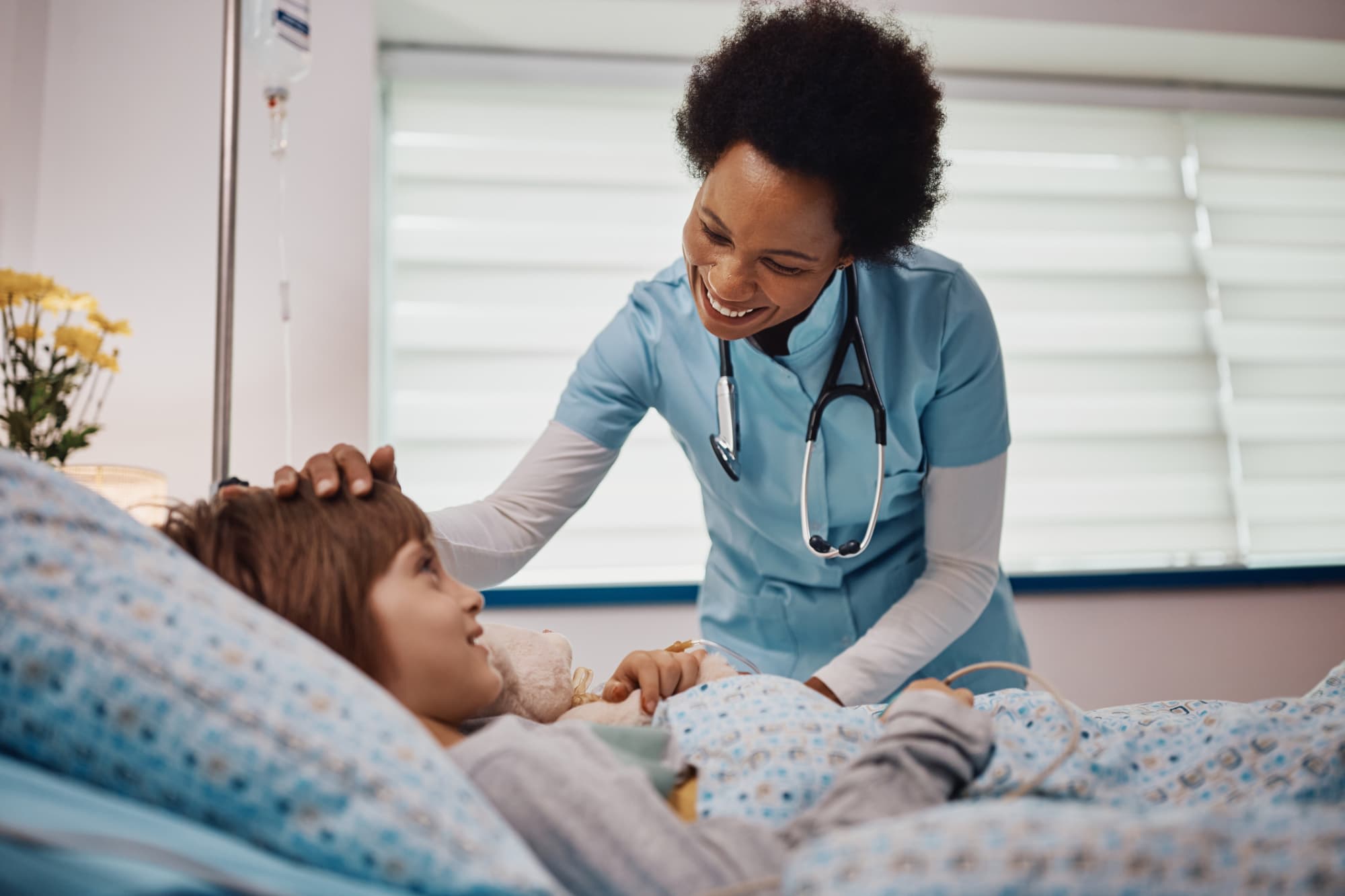 Nurse touching a child patient's head and smiling
