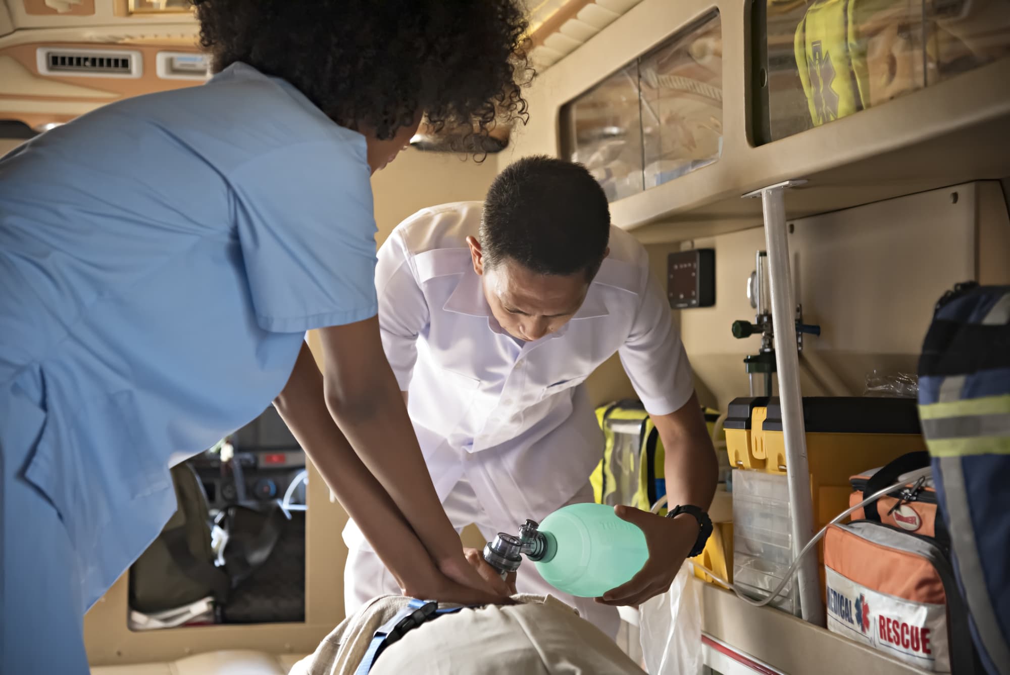 Nurse administering CPR on patient in ambulance