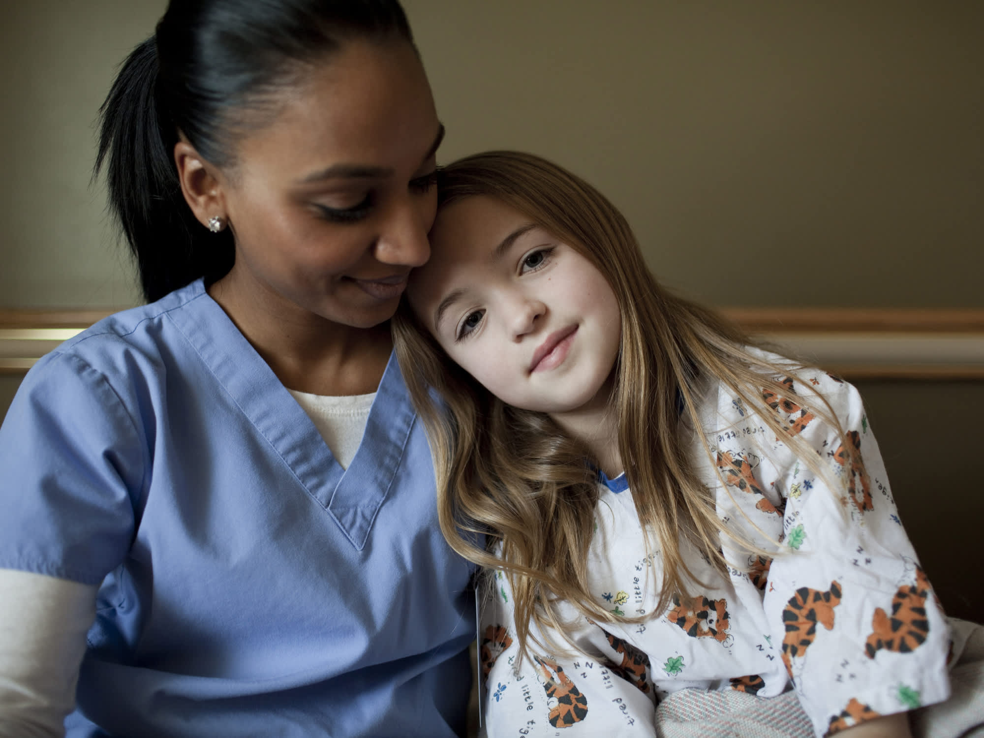 A nurse embraces a young patient.