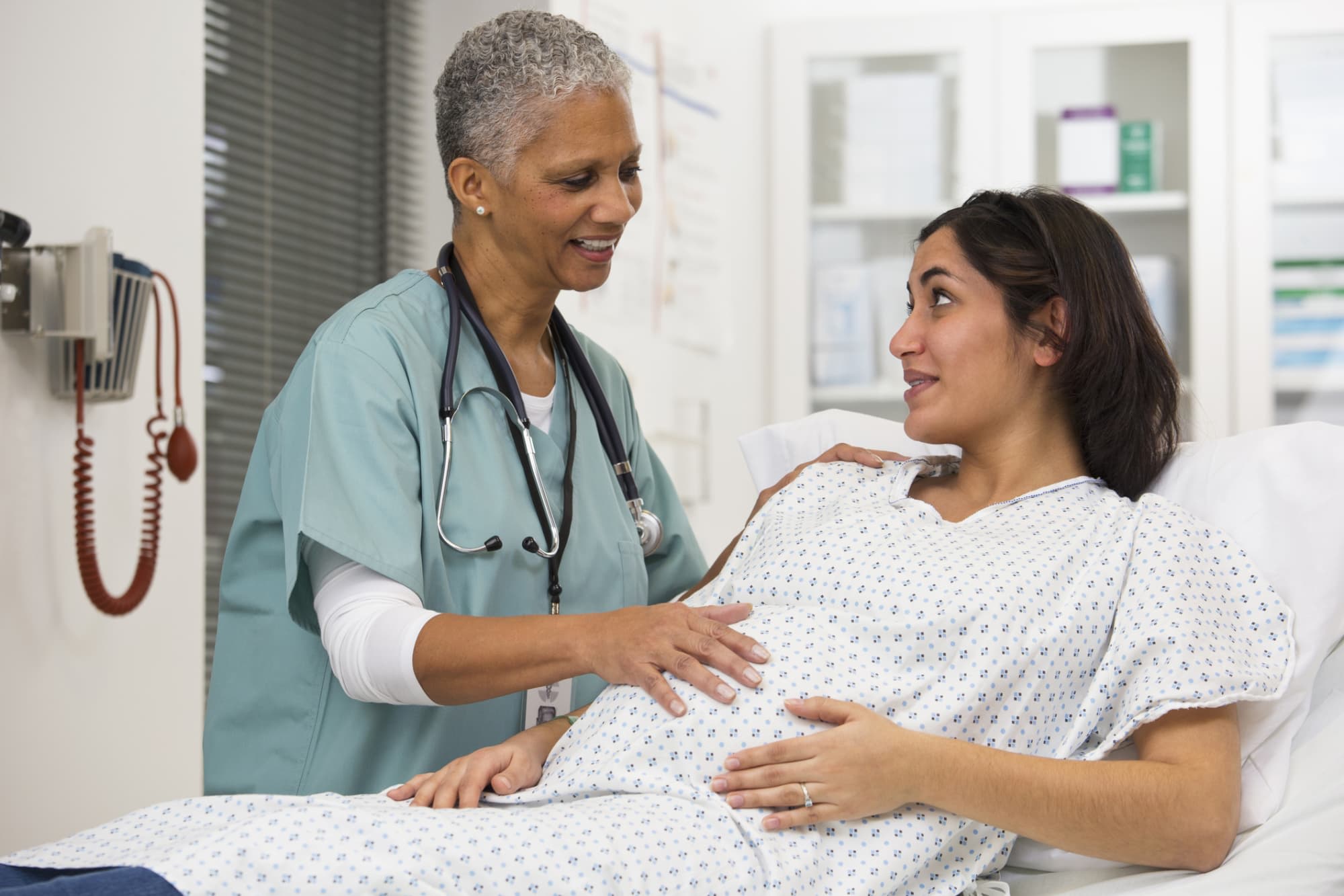 Nurse examining pregnant patient's belly