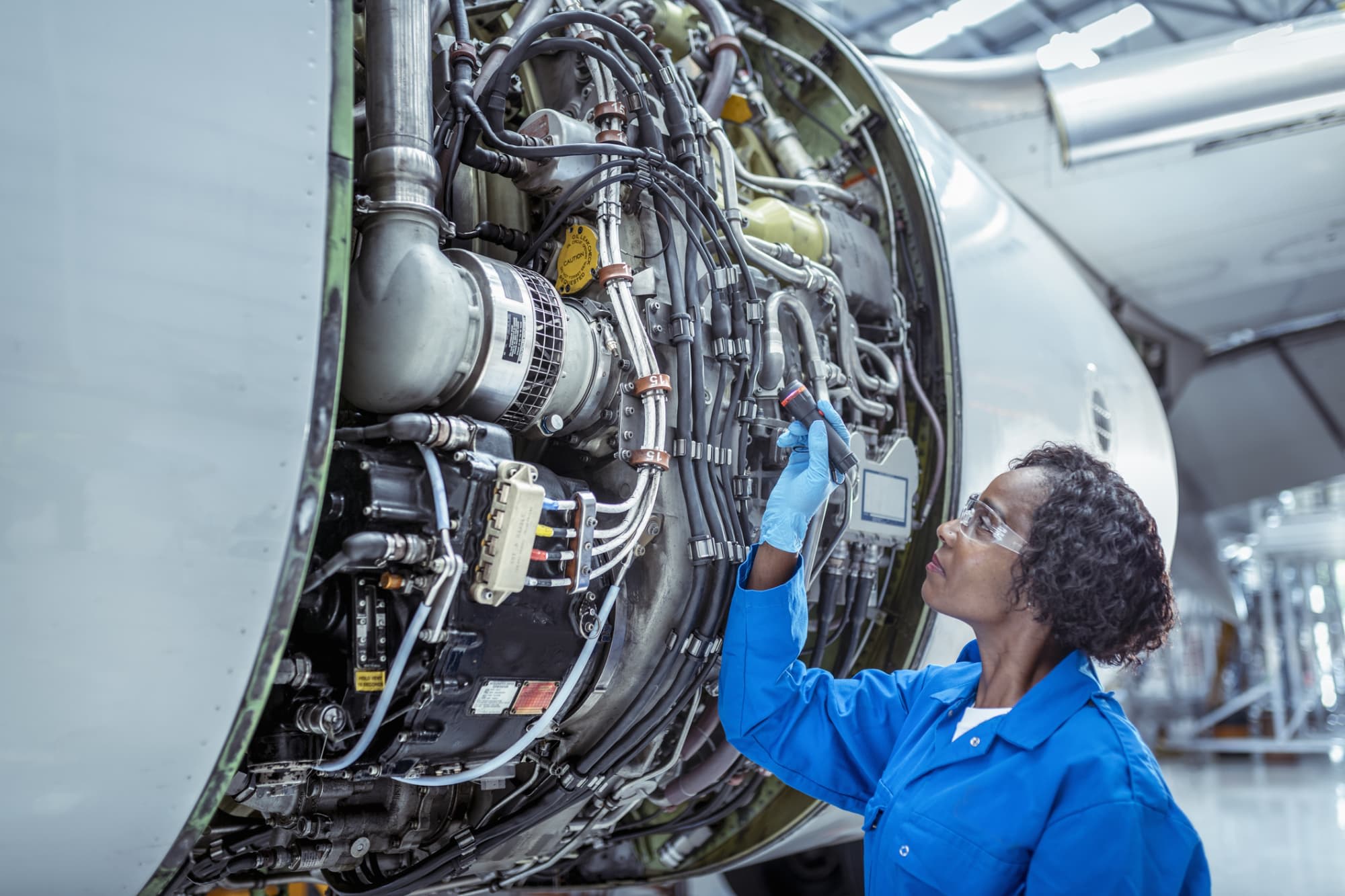 Woman engineer inspecting jet engine