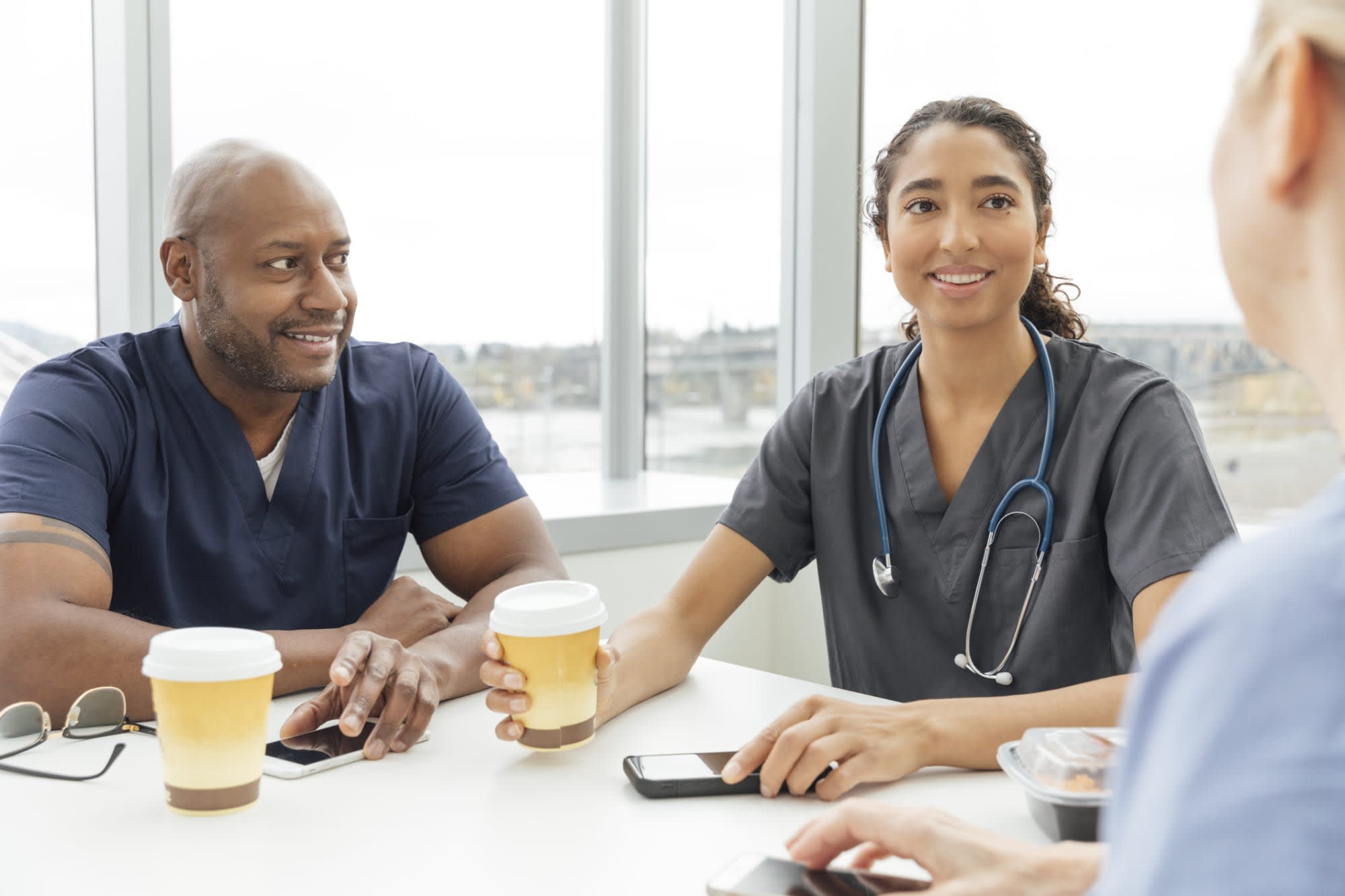 Nurses talking to each other at a cafe table