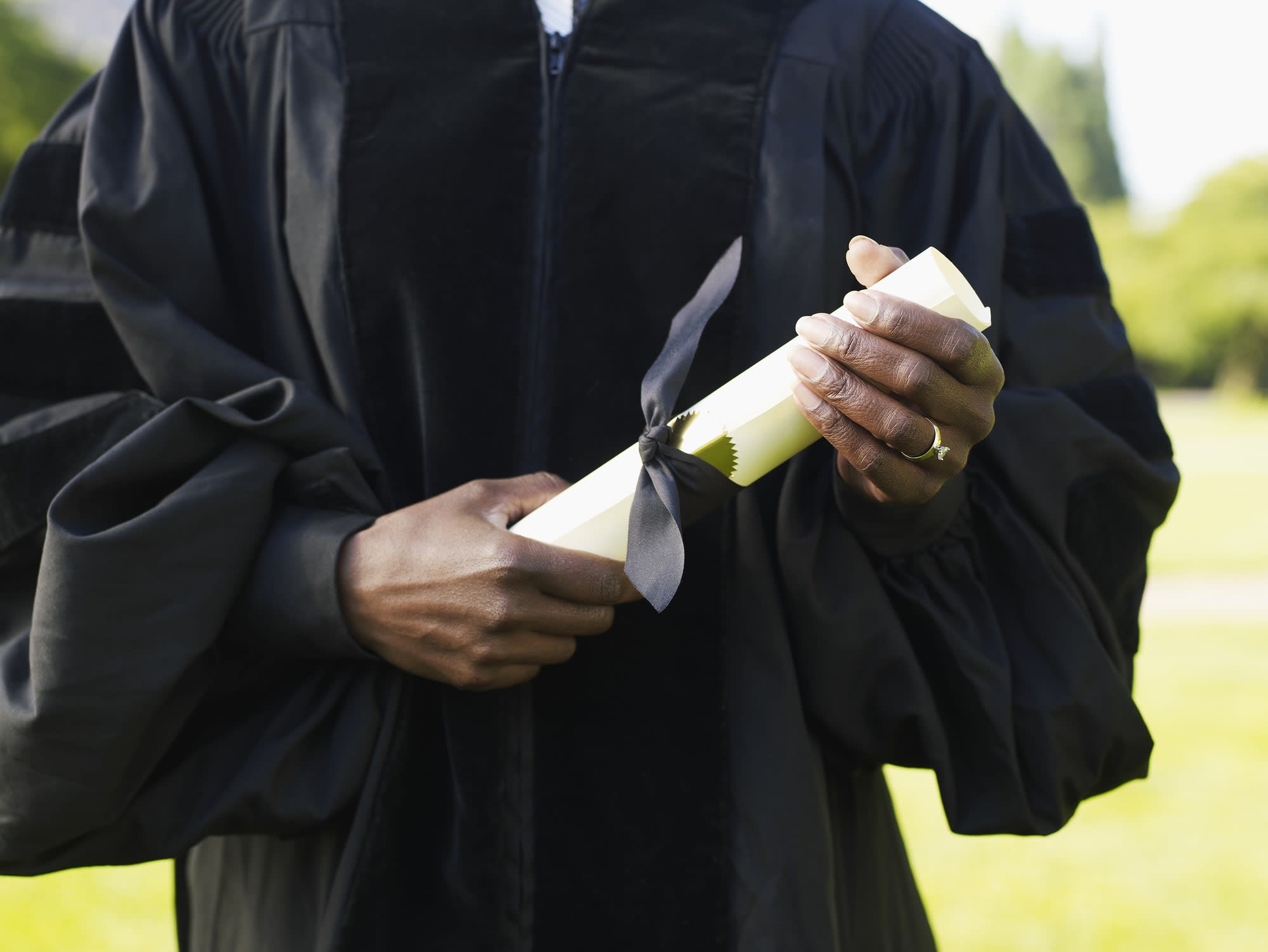 Graduate at commencement holding diploma