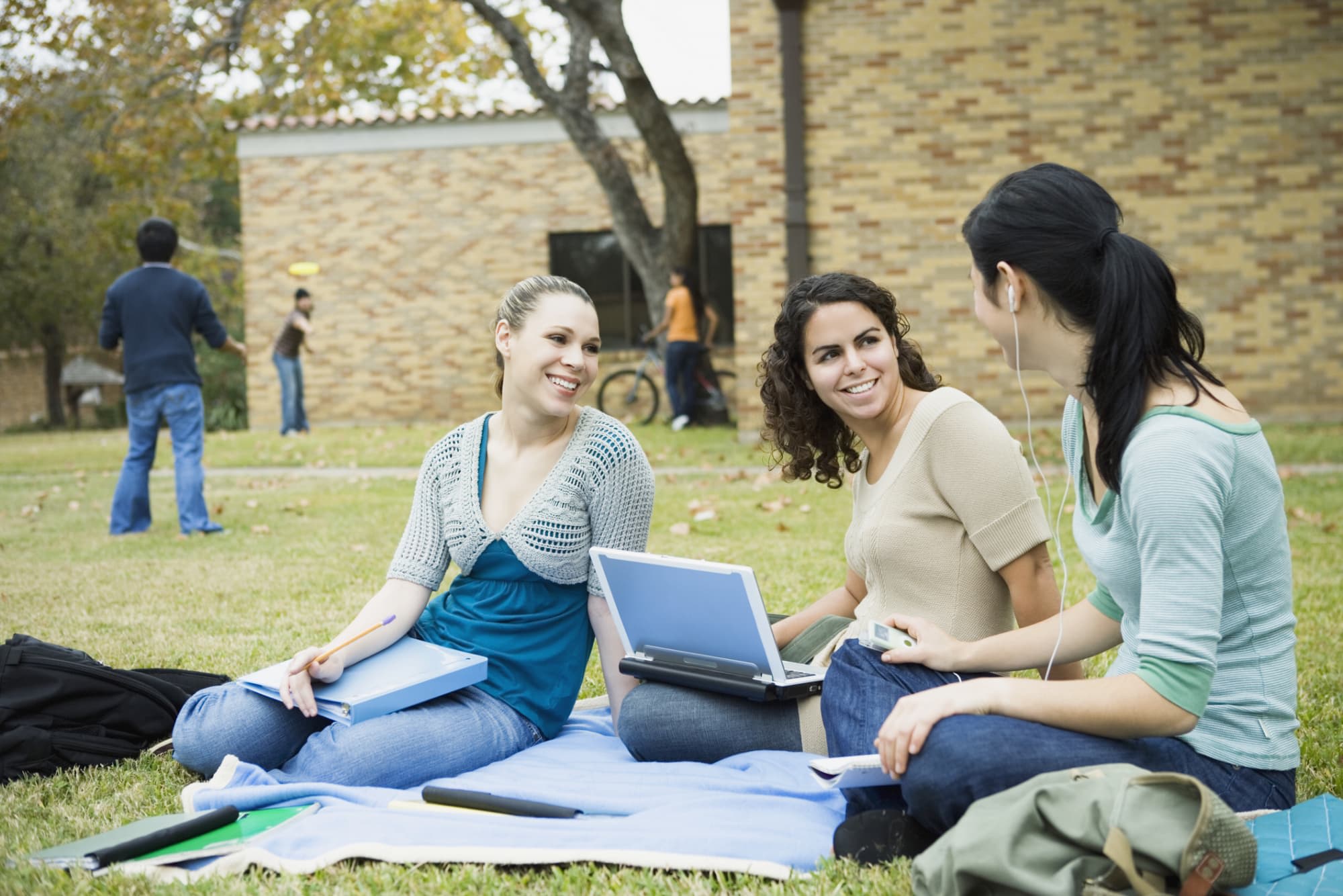 Three women college students studying together outside