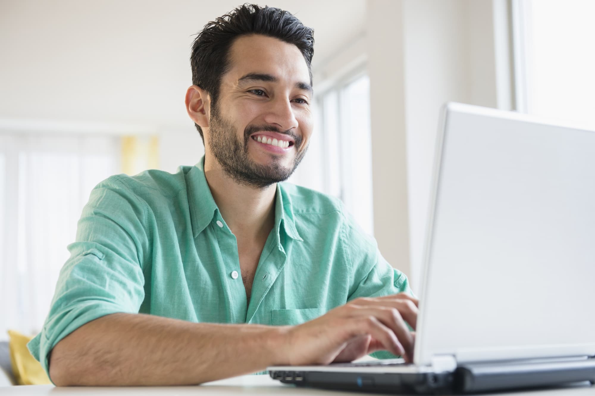 Man typing cover letter on a laptop