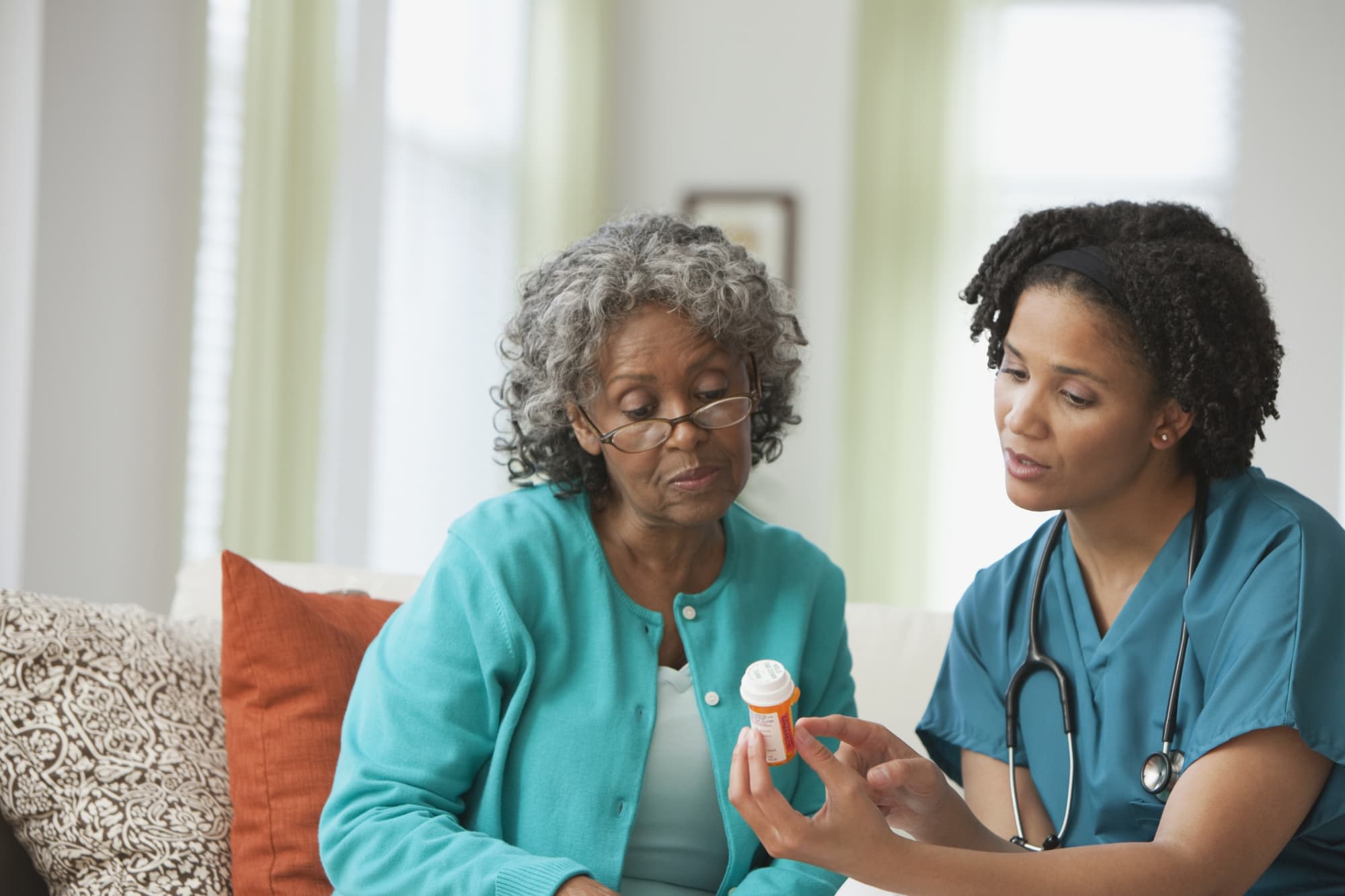 Home nurse helping patient with medication
