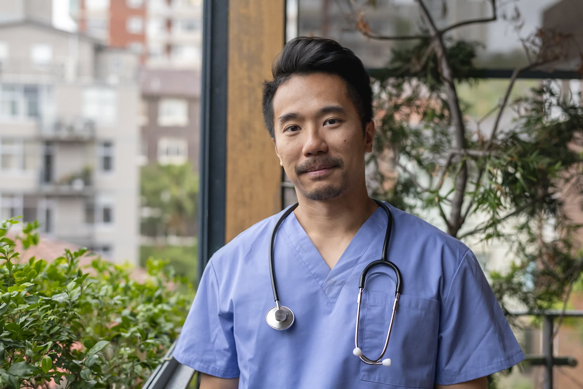 Male nurse standing outside of a hospital