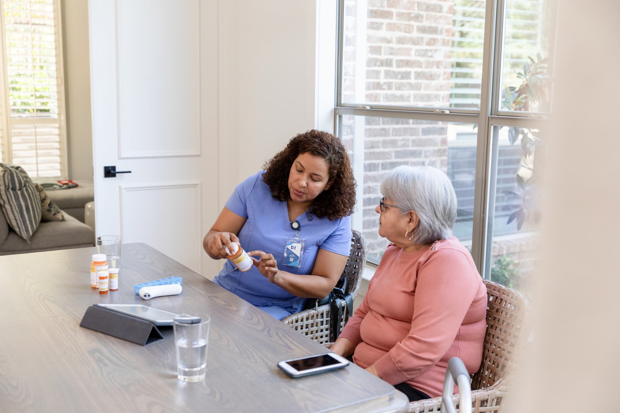 Nurse helping a senior patient with her medications at home