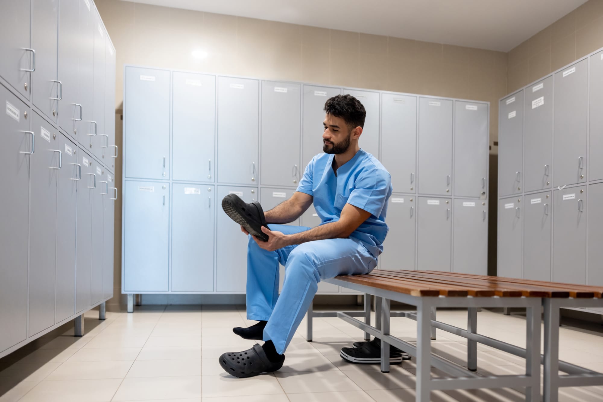 Nurse putting shoes on in locker room