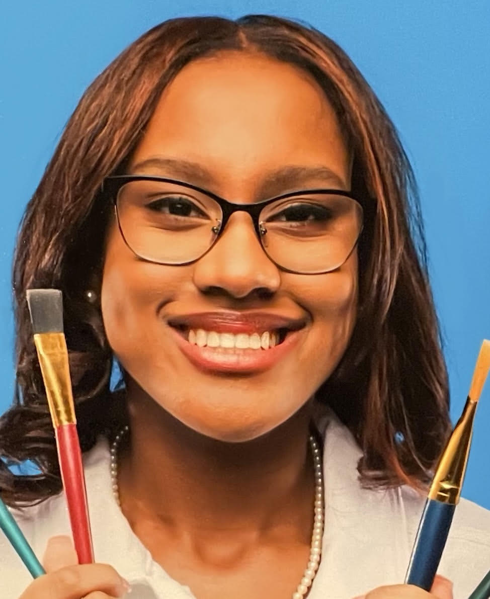 Jada Taylor's headshot holding paint brushes.