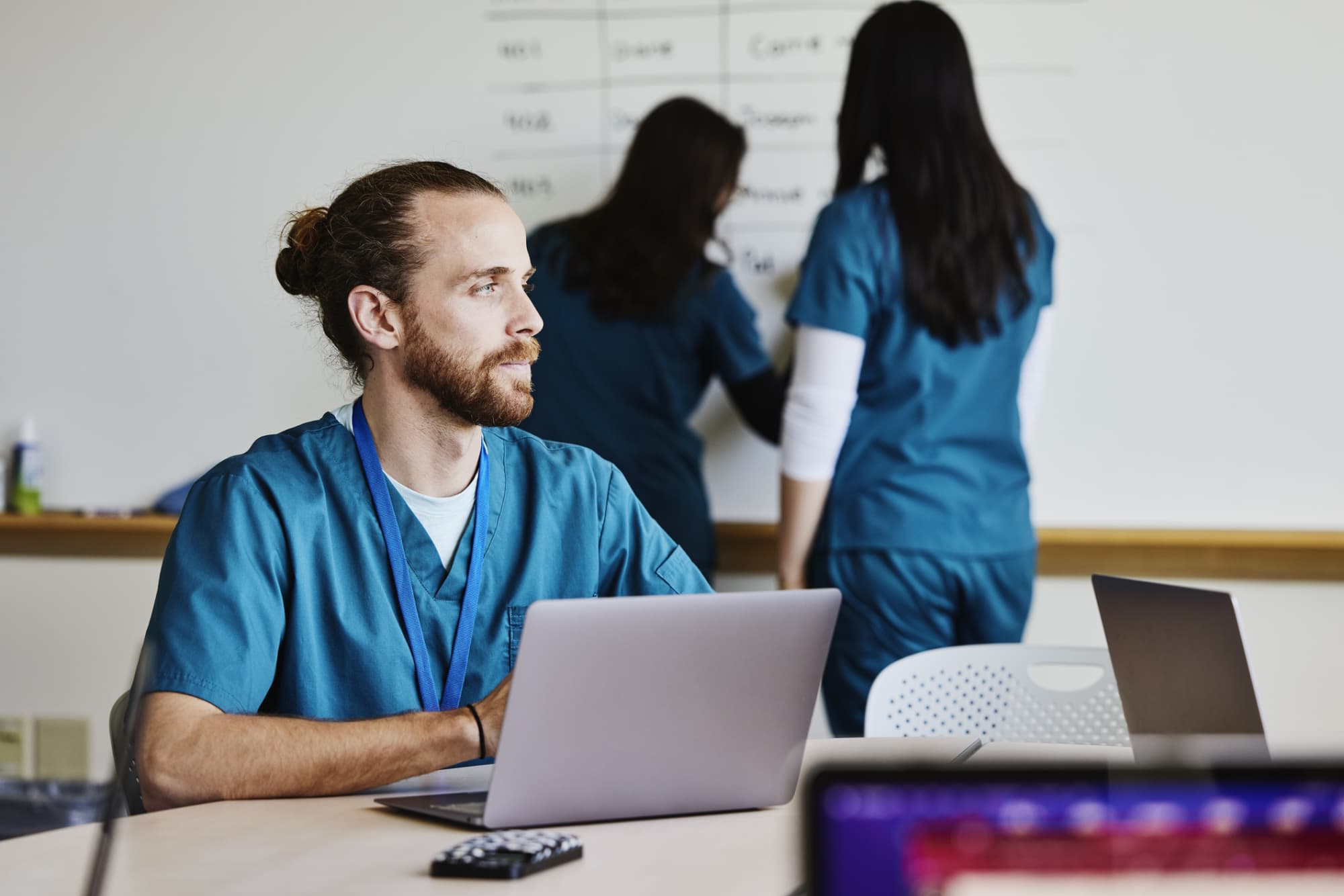 Nurse working in conference room, looking tired and sad