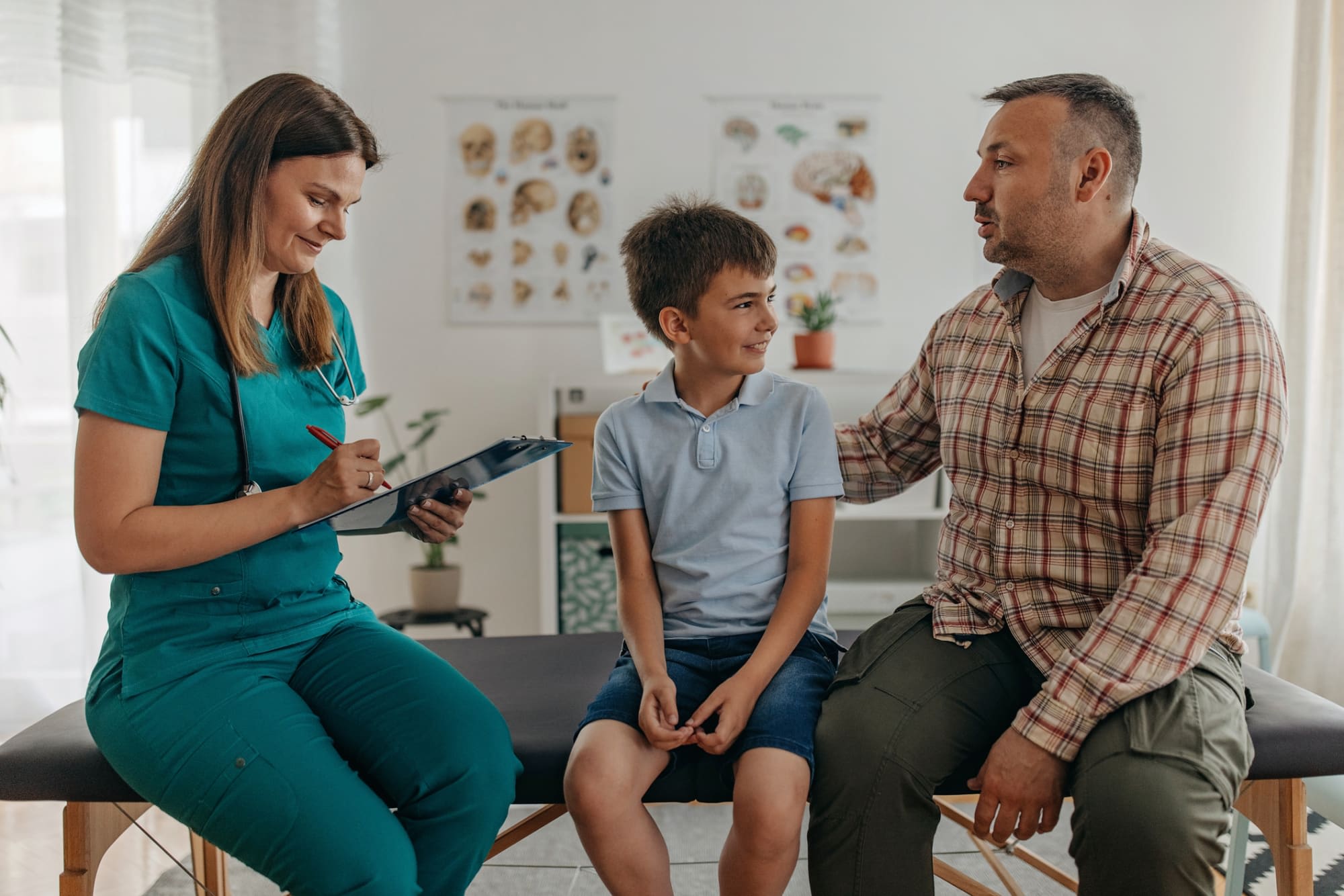 Nurse taking notes during appointment with father and son patient