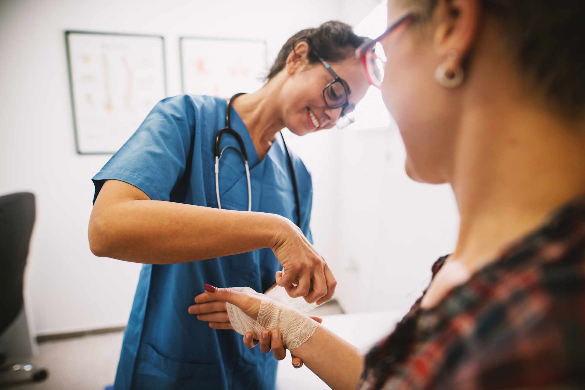 Wound care nurse helping patient with her hand