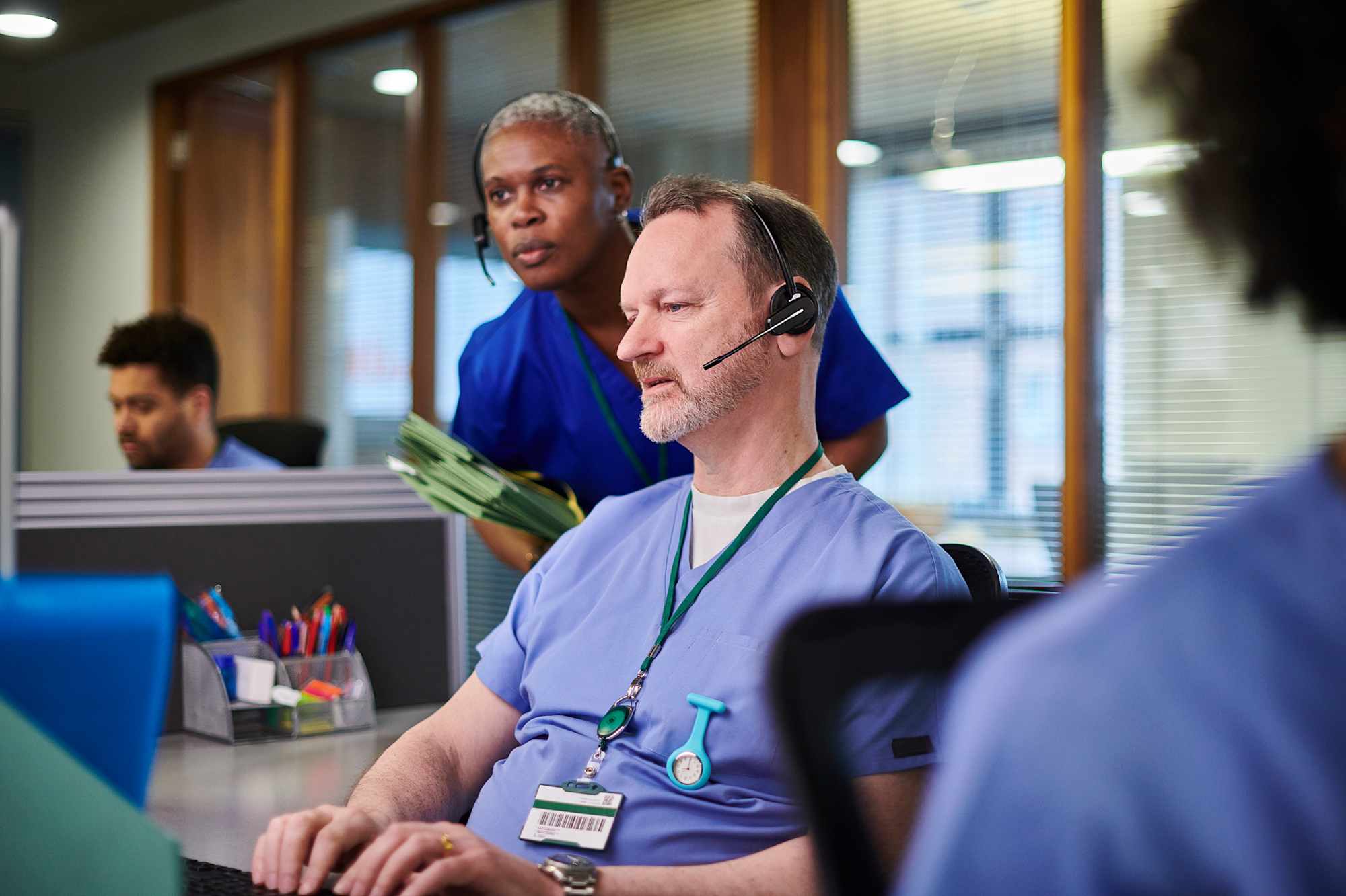 Healthcare professionals on computers in office