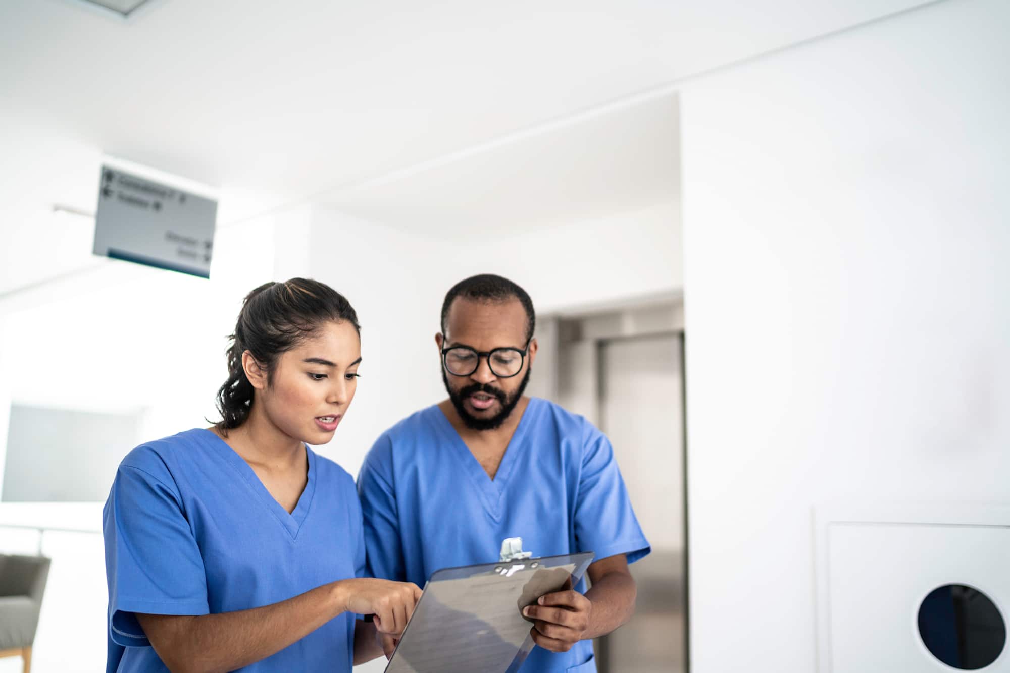Nurses walking and talking at corridor hospital