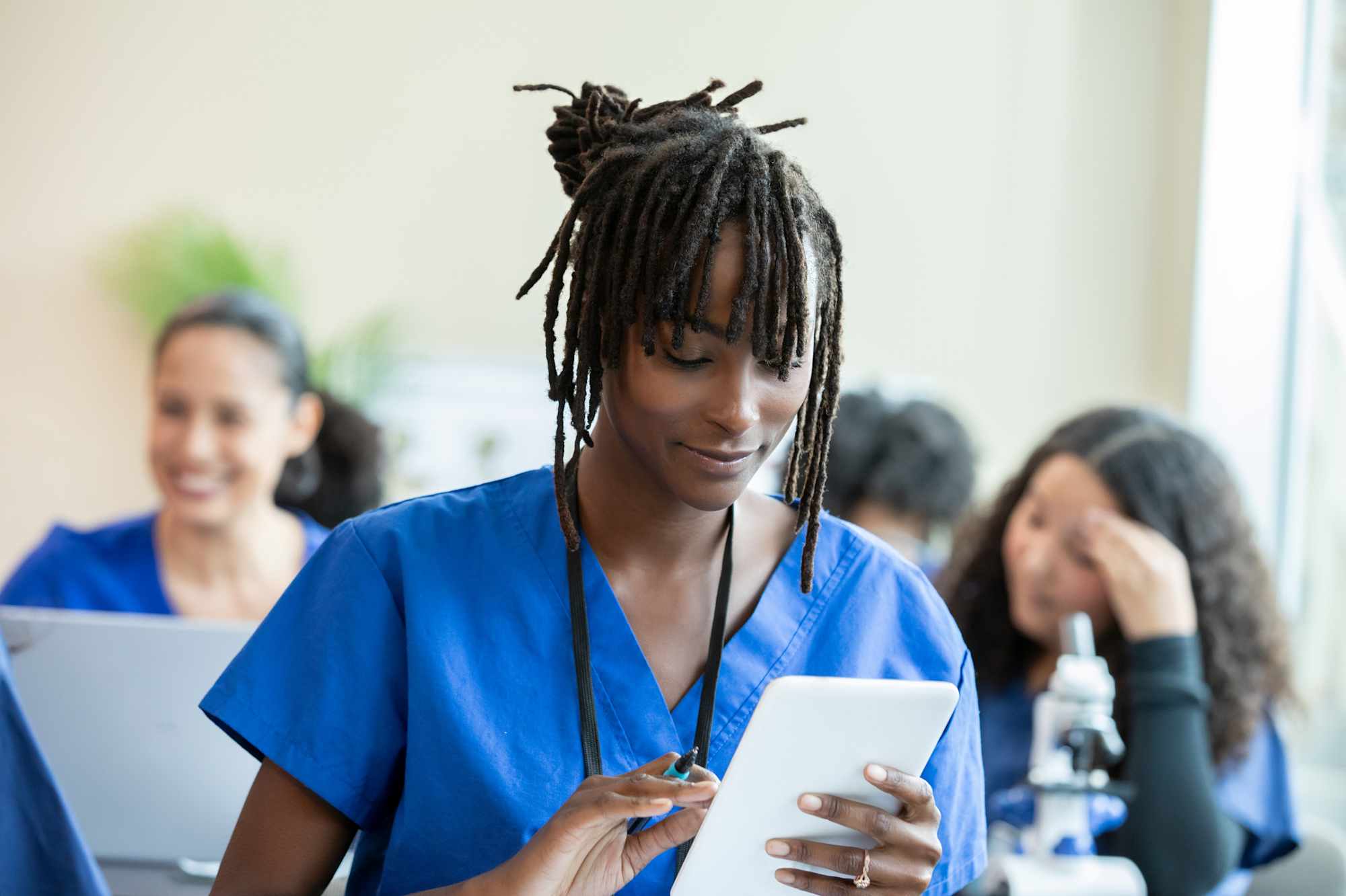 Nursing student working on tablet in classroom