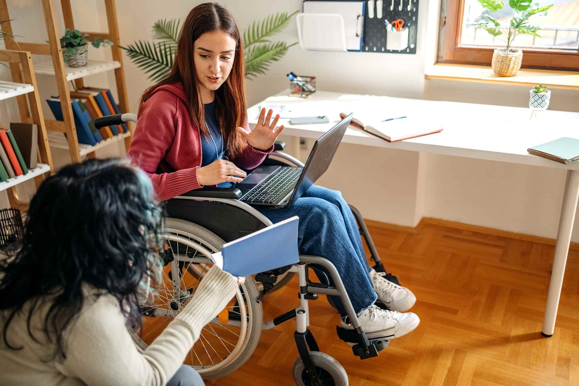 Student in wheelchair studying with roommate