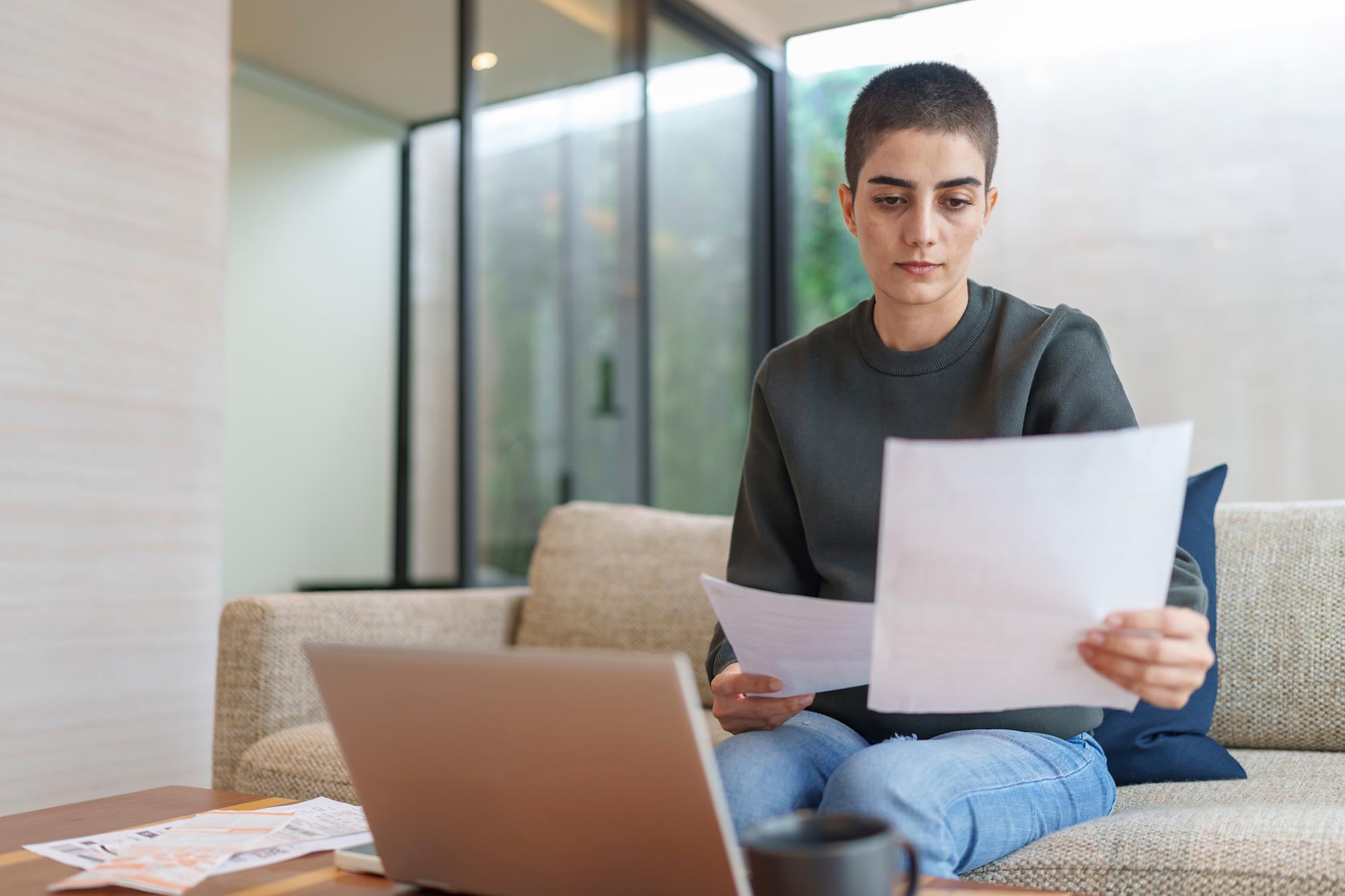 Online student looking at documents and working on laptop