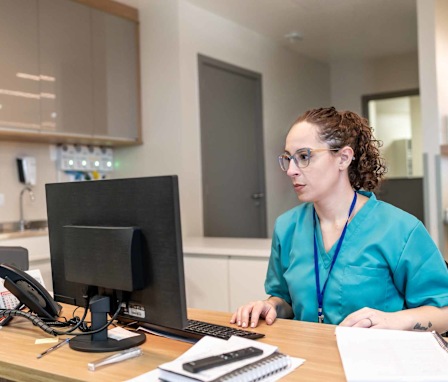 Medical coder at computer in hospital