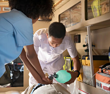 Nurse administering CPR on patient in ambulance