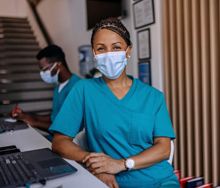 Medical assistant wearing mask at a desk