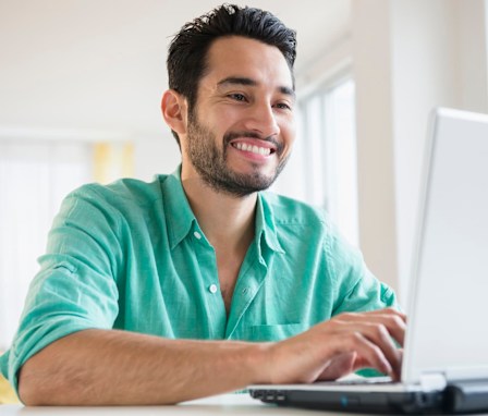 Man typing cover letter on a laptop